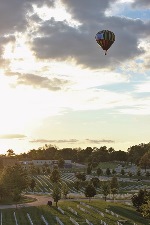 A hot air balloon flies over Jefferson Barracks National Cemetery, Missouri in the early hours of the morning.