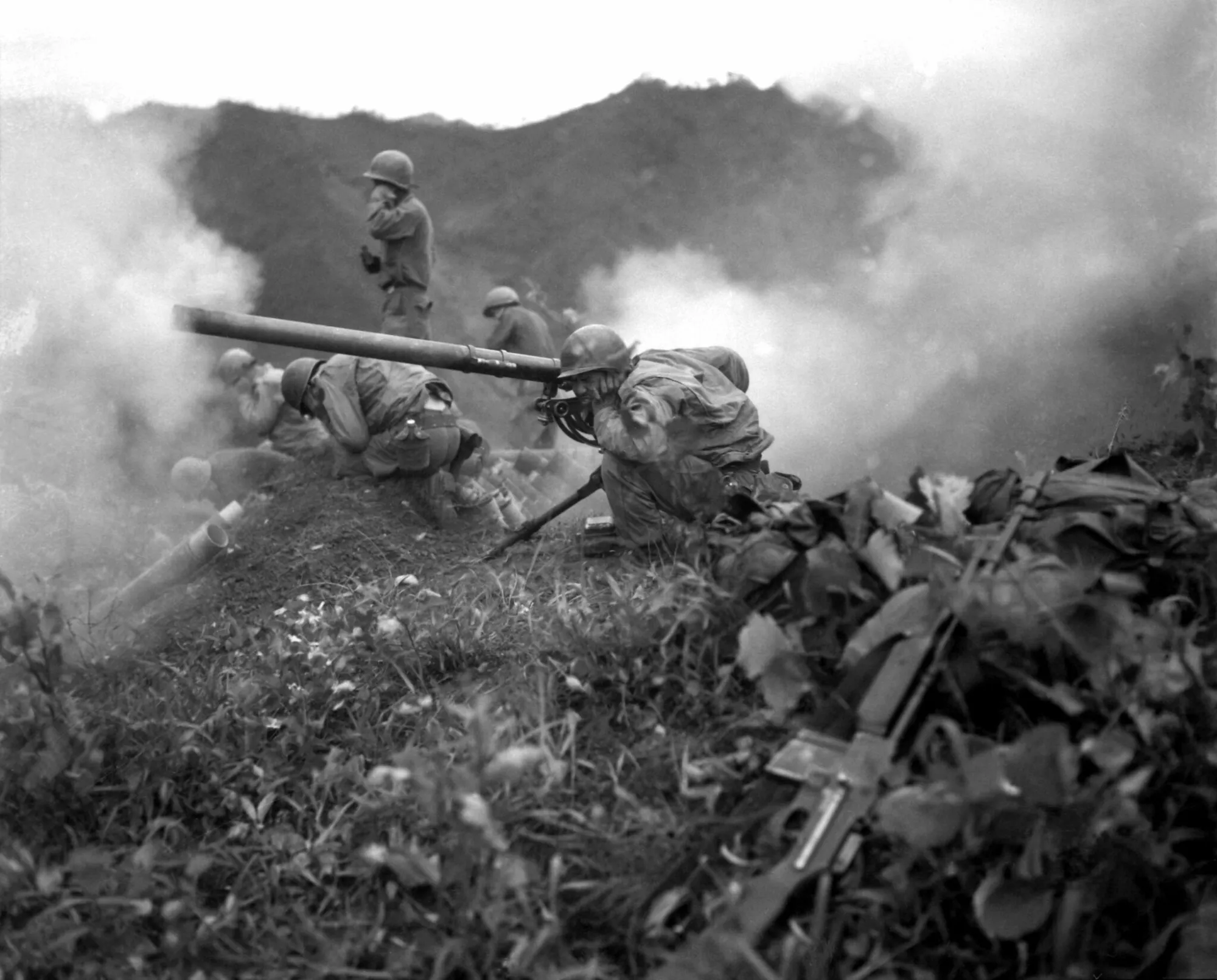 Guns firing on a ridge somewhere in Korea.